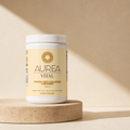 Aurea Vital Grass-Fed Collagen Creamer in a warm travertine studio setting.